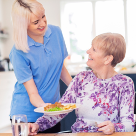 caregiver bringing senior meal