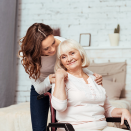 young woman checking senior woman on wheelchair