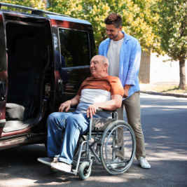 caregiver helping senior man into transport