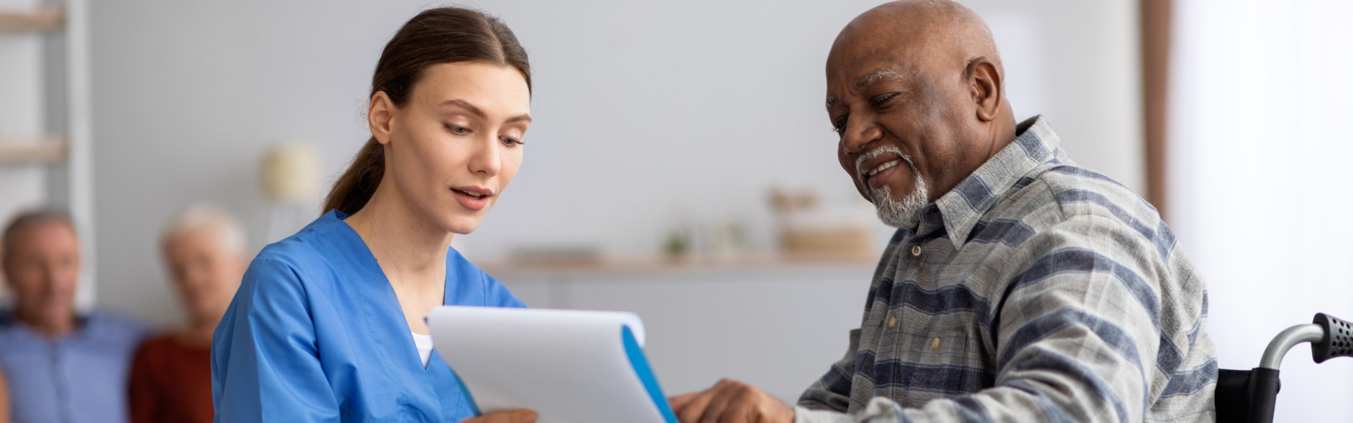 caregiver helping senior sign