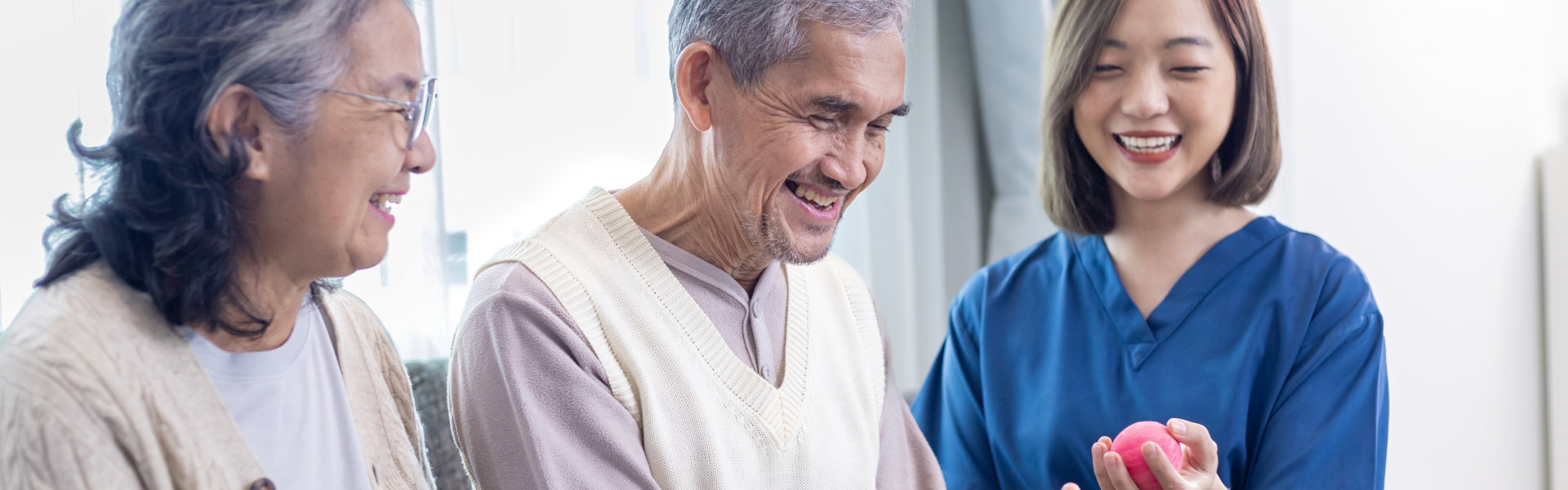 Senior couple got medical service visit from caregiver nurse while using round squishy ball for muscle strength in pension retirement center for rehabilitation and longevity post recovery process